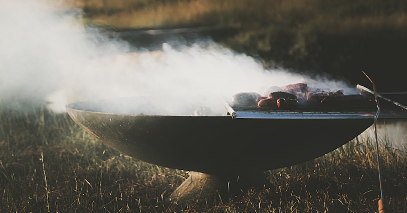 lighted black metal grill with meat on top