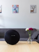 A cozy living room setup featuring a sleek smart speaker on a wooden side table.