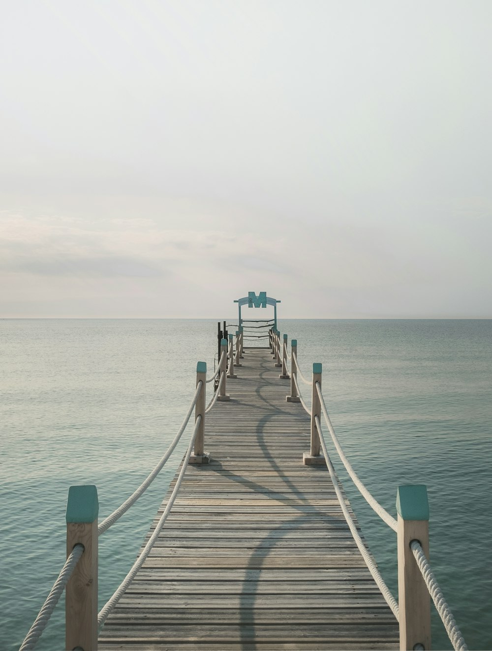 穏やかな水域の近くの茶色の木製の桟橋