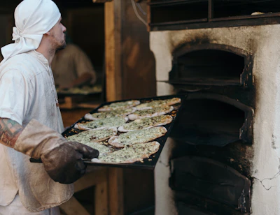 Chef expertly layering fresh ingredients inside warm flatbread at the counter.