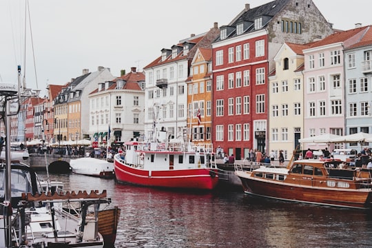 red and white boat on body of water in Nyhavn Denmark