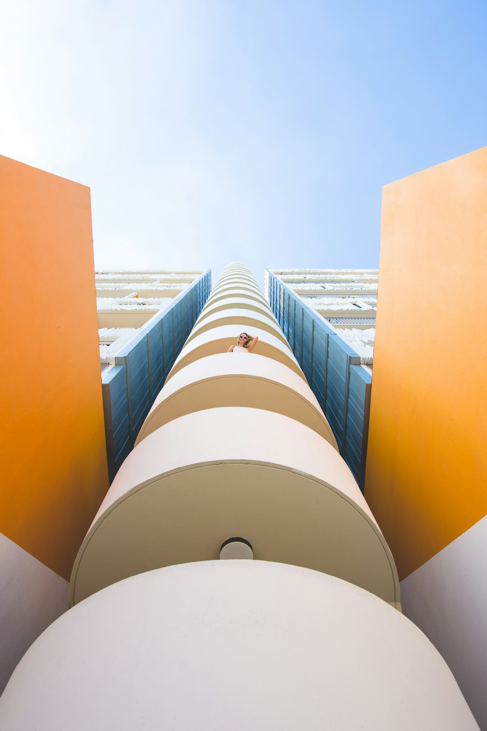 worm's eye view of a woman at the 3rd floor of a building