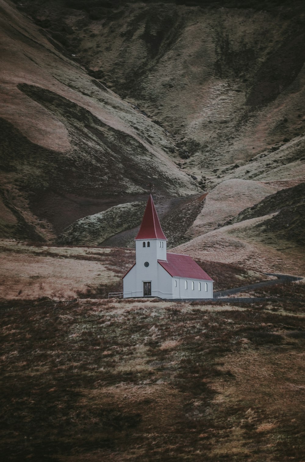 Landschaftsfotografie eines weißen und roten Betonhauses in der Nähe eines Berges