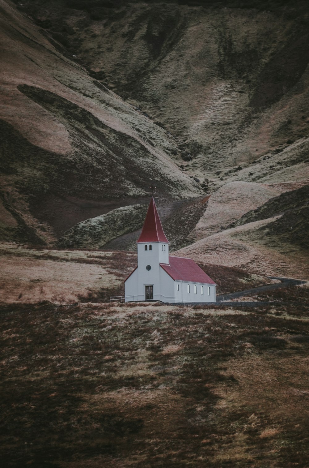 landscape photography of white and red concrete house near mountain