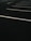 A dimly lit, empty parking lot with white painted lines marking parking spaces. The dark asphalt and overcast lighting create a sense of solitude.