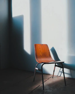Dark industrial-style modern chair with metal and wood textures in a moody room