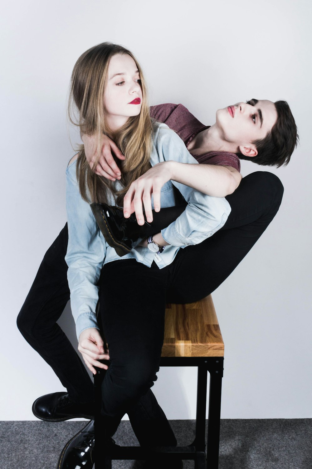 man and woman doing contemporary position while sitting on brown wooden stool