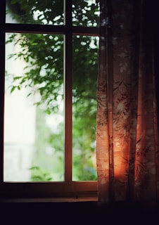 brown and black floral curtains near green leafed trees