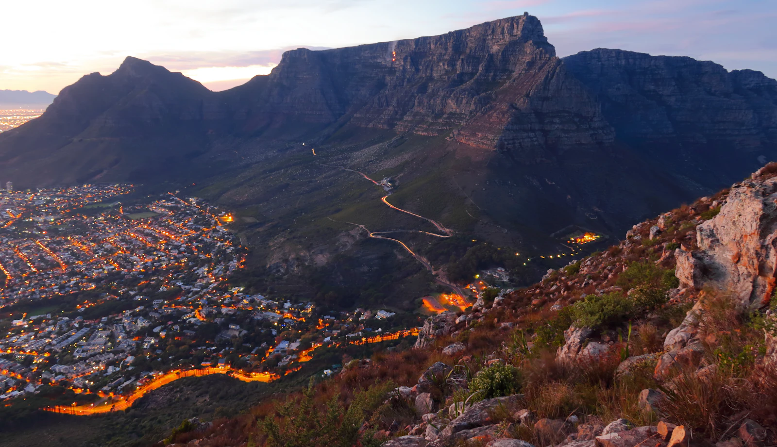 Table Mountain above Cape Town at dusk, the city lights coming on