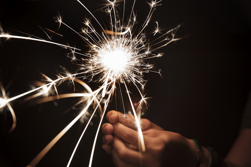 person holding lighted sparkler