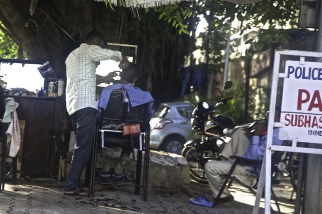 Barber delivering a haircut at a cozy home setting in Saint-Germain-de-Grantham.