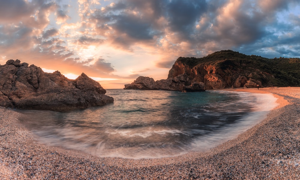 seashore near rock formation at golden hour