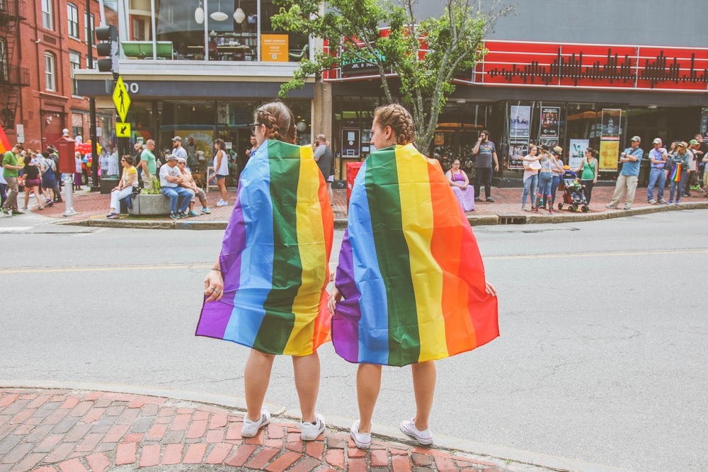 two women standing near curb during daytime