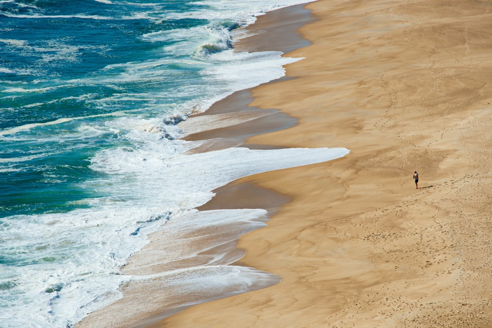 homme marchant au milieu du rivage