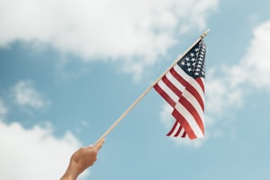 A close-up of hands holding a folded American flag.