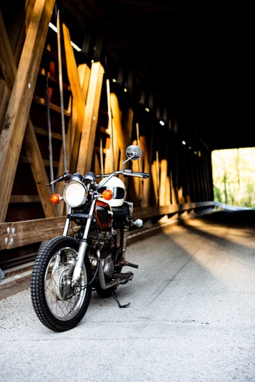 black motorcycle near brown wooden tunnel bridge