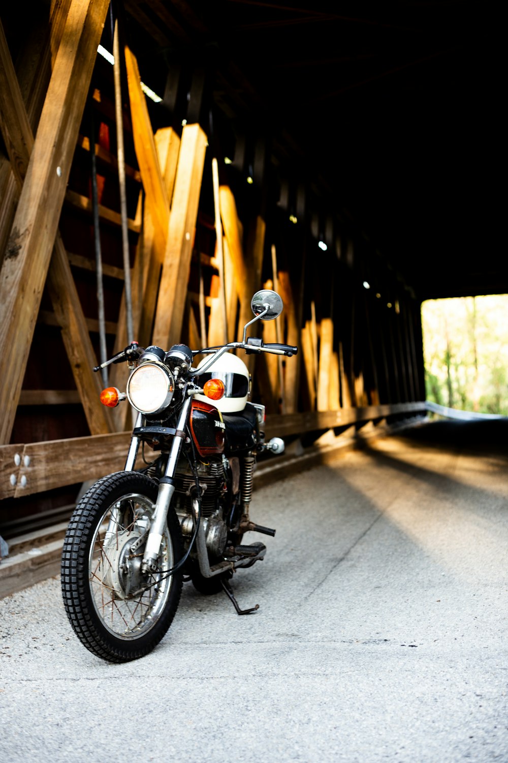 Schwarzes Motorrad in der Nähe der braunen Holztunnelbrücke