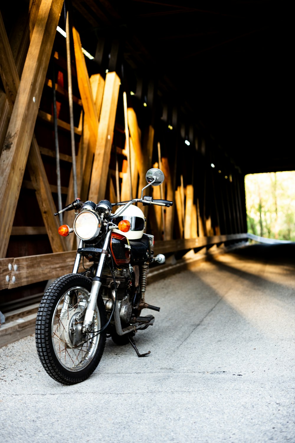 Motocicleta preta perto da ponte marrom do túnel de madeira