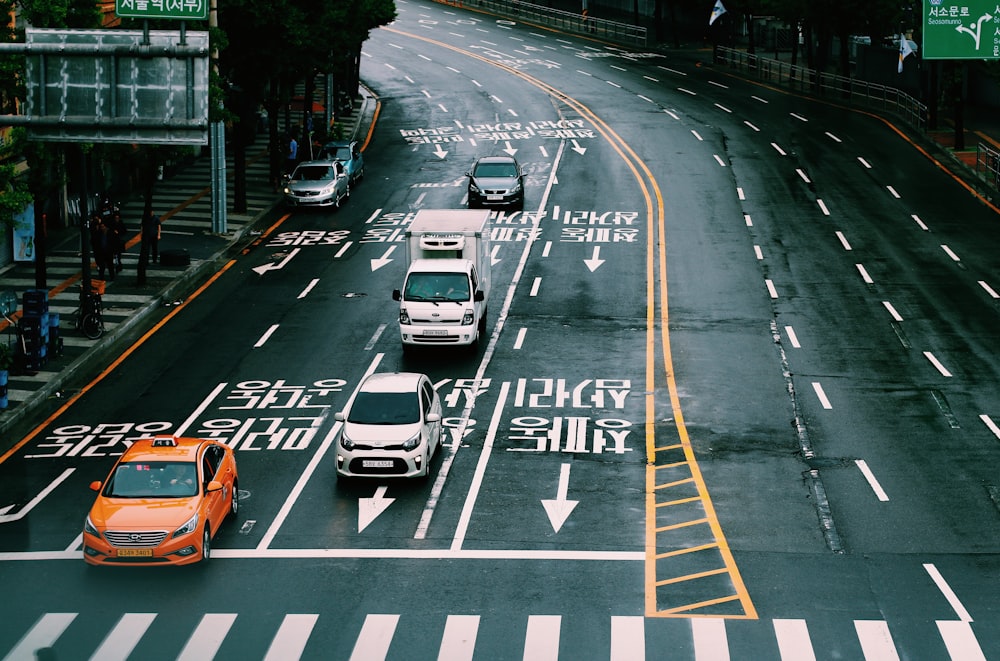 昼間に撮影された灰色のコンクリート道路を走る車両