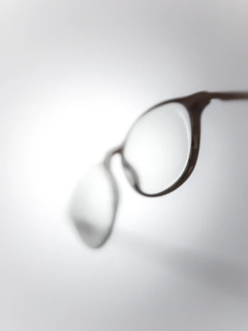 Close-up of trendy cat-eye glasses with a soft-focus floral backdrop.