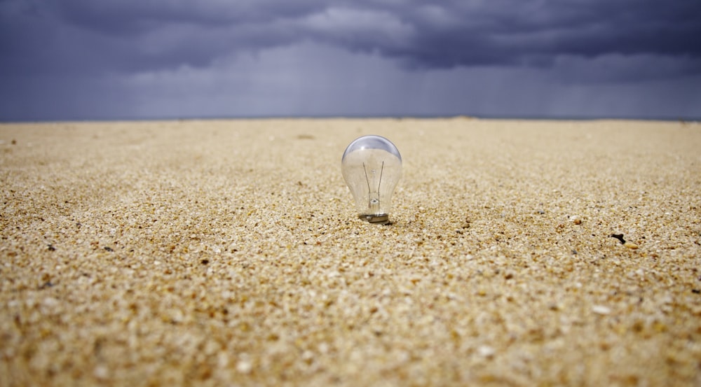 photographie en gros plan de l’ampoule LED sur le sable