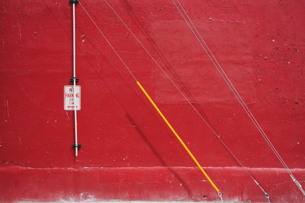 a red wall with a street sign on it