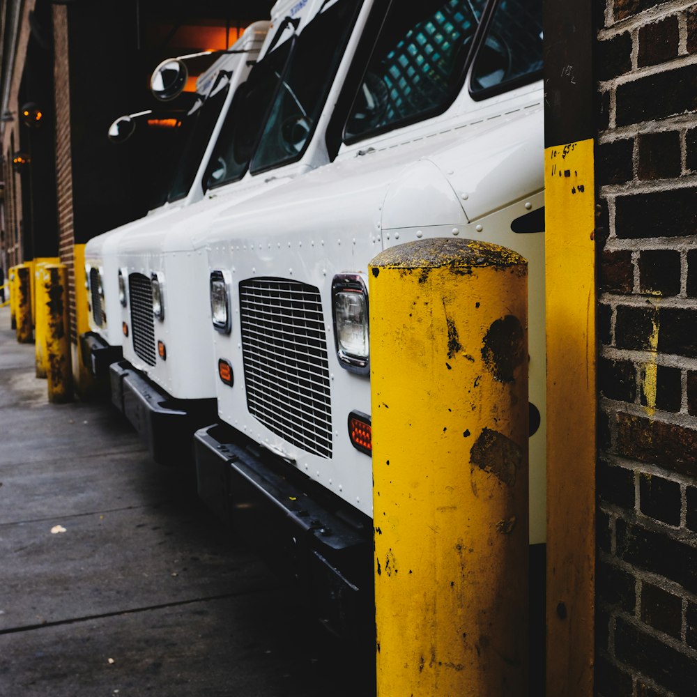 three white vehicle parked on garage