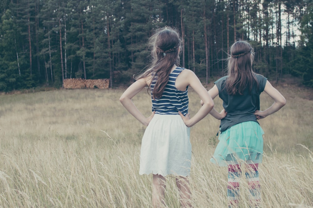 two girls standing while holding her hips