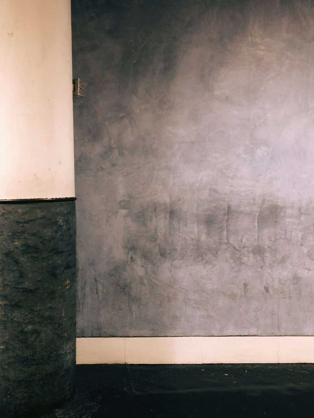 a person sitting on a bench in front of a wall