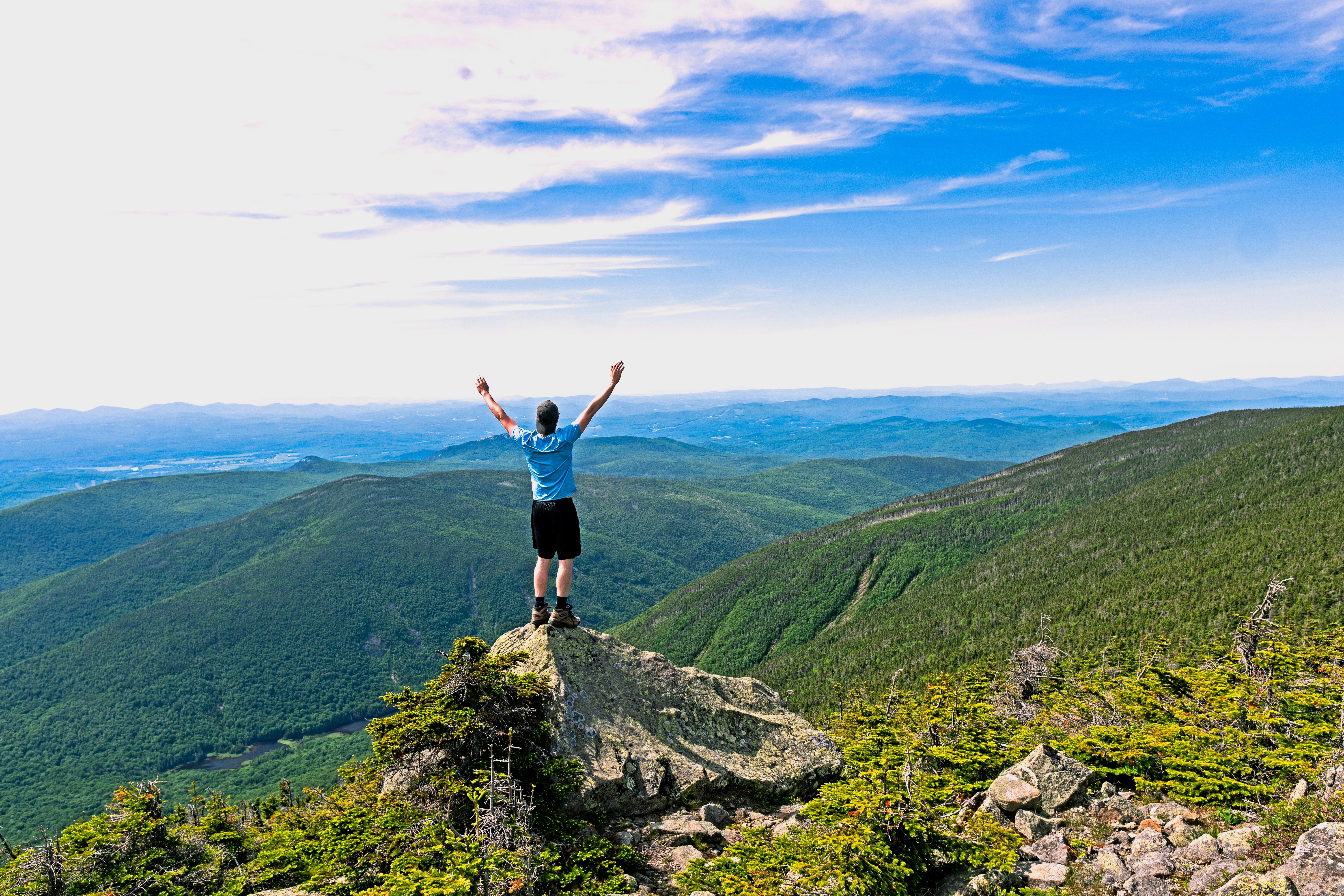 man raising his hands standing on mountain range, Feeling free on an overnight hiking trip in the White Mountain National Forest in New Hampshire. This photo reminds me that the world is beautiful and our lives improve drastically once we realize that we control our destiny.
