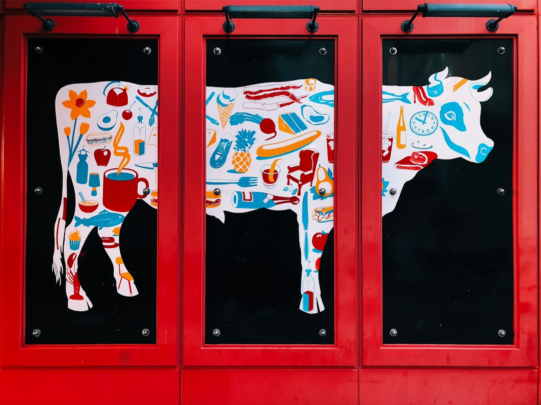 white, blue, and red cow 3-panel painting on wall