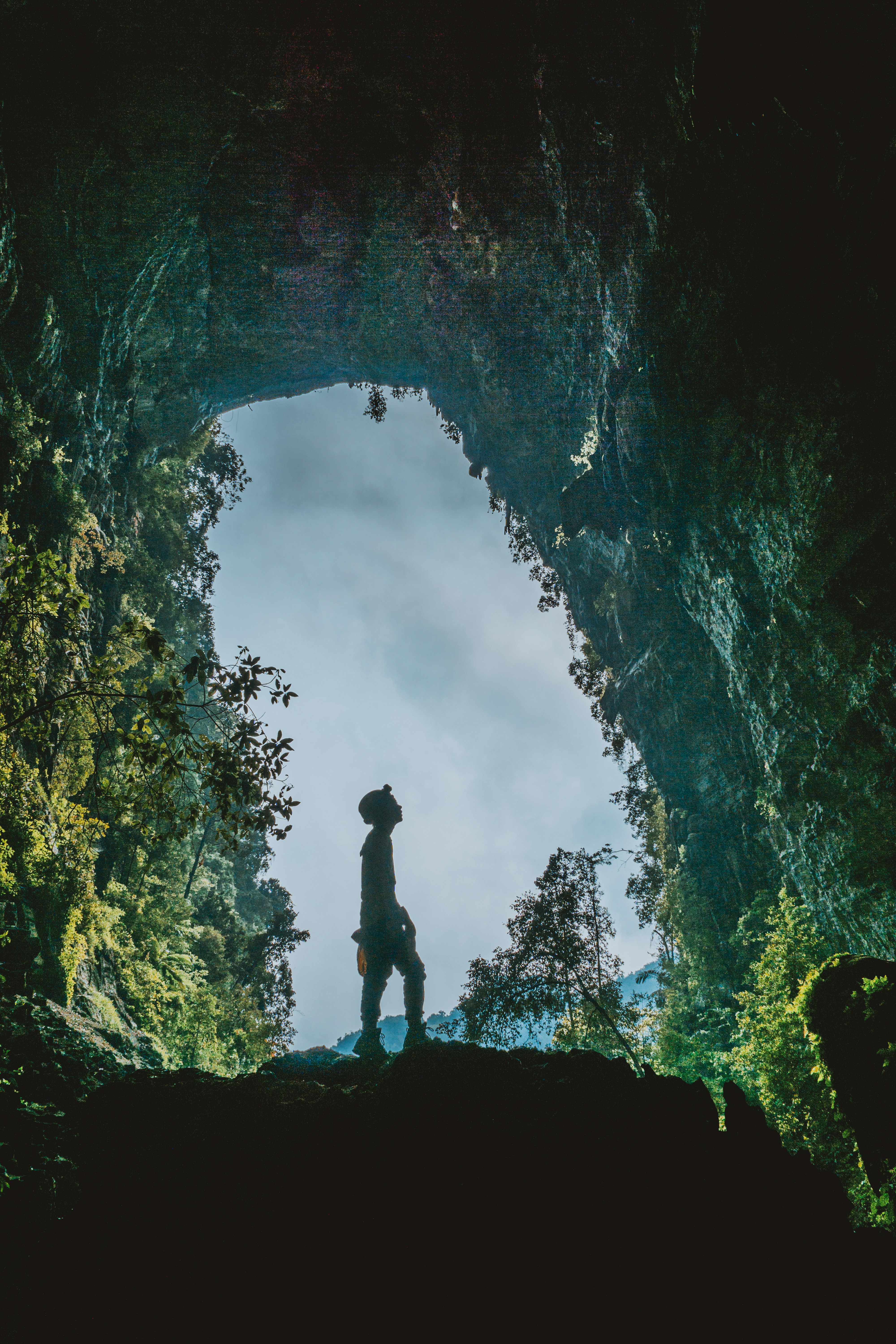 silhouette of man standing in cave
