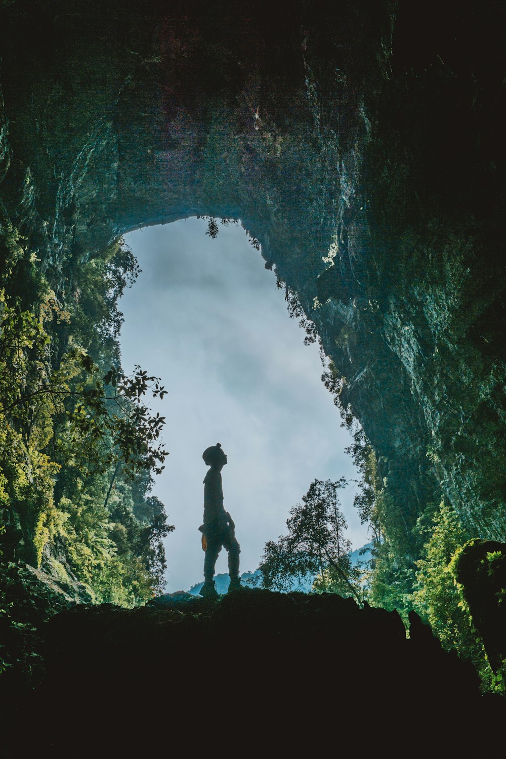 silhouette of man standing in cave