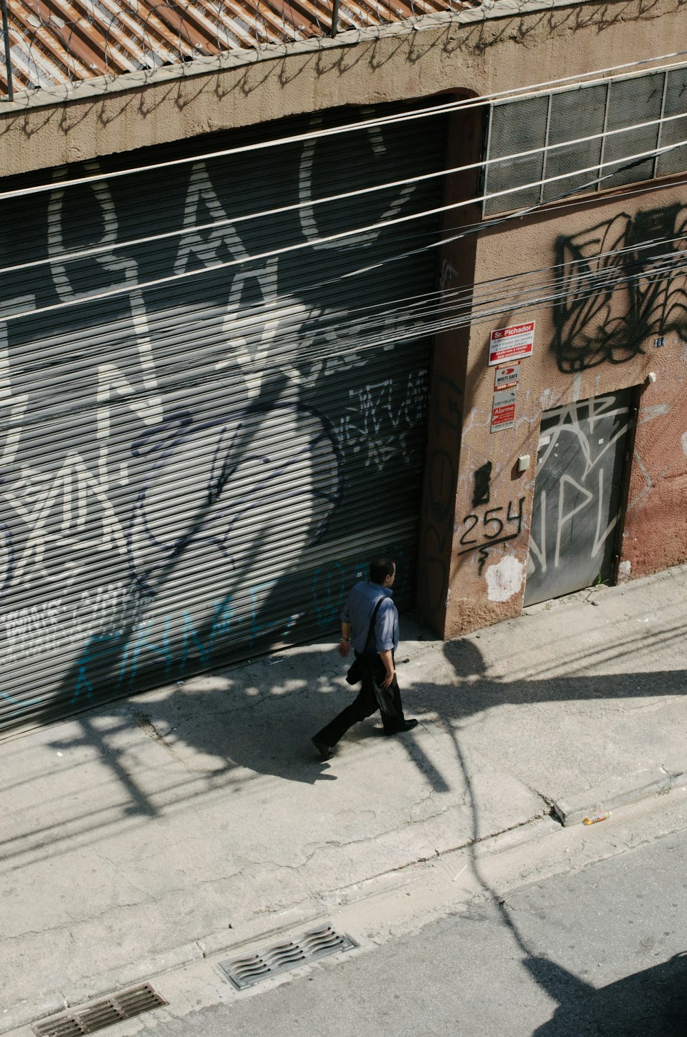 a man walking down a street next to a building