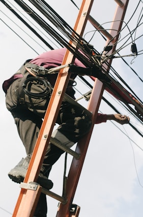 A construction worker installing fiber optic cables in a trench.