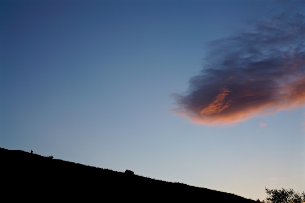 silhouette de pente de montagne sous ciel nuageux
