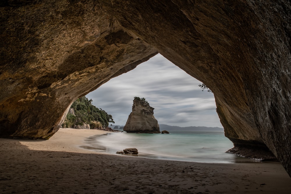 cave beside calm body of water