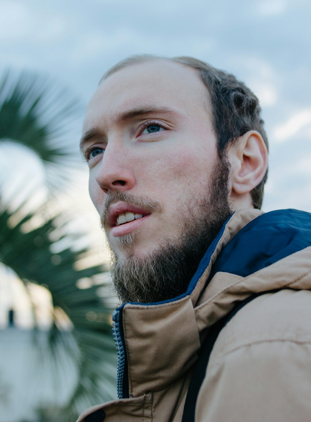 man wearing blue jacket looking in distance