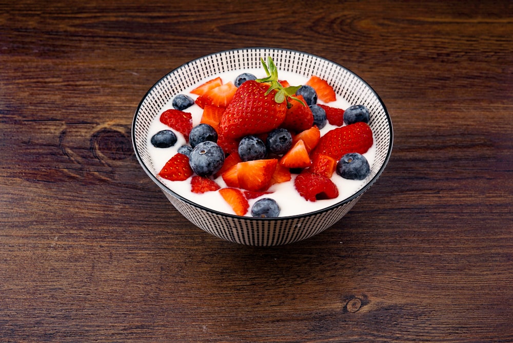 strawberry and blackberries on top of brown table