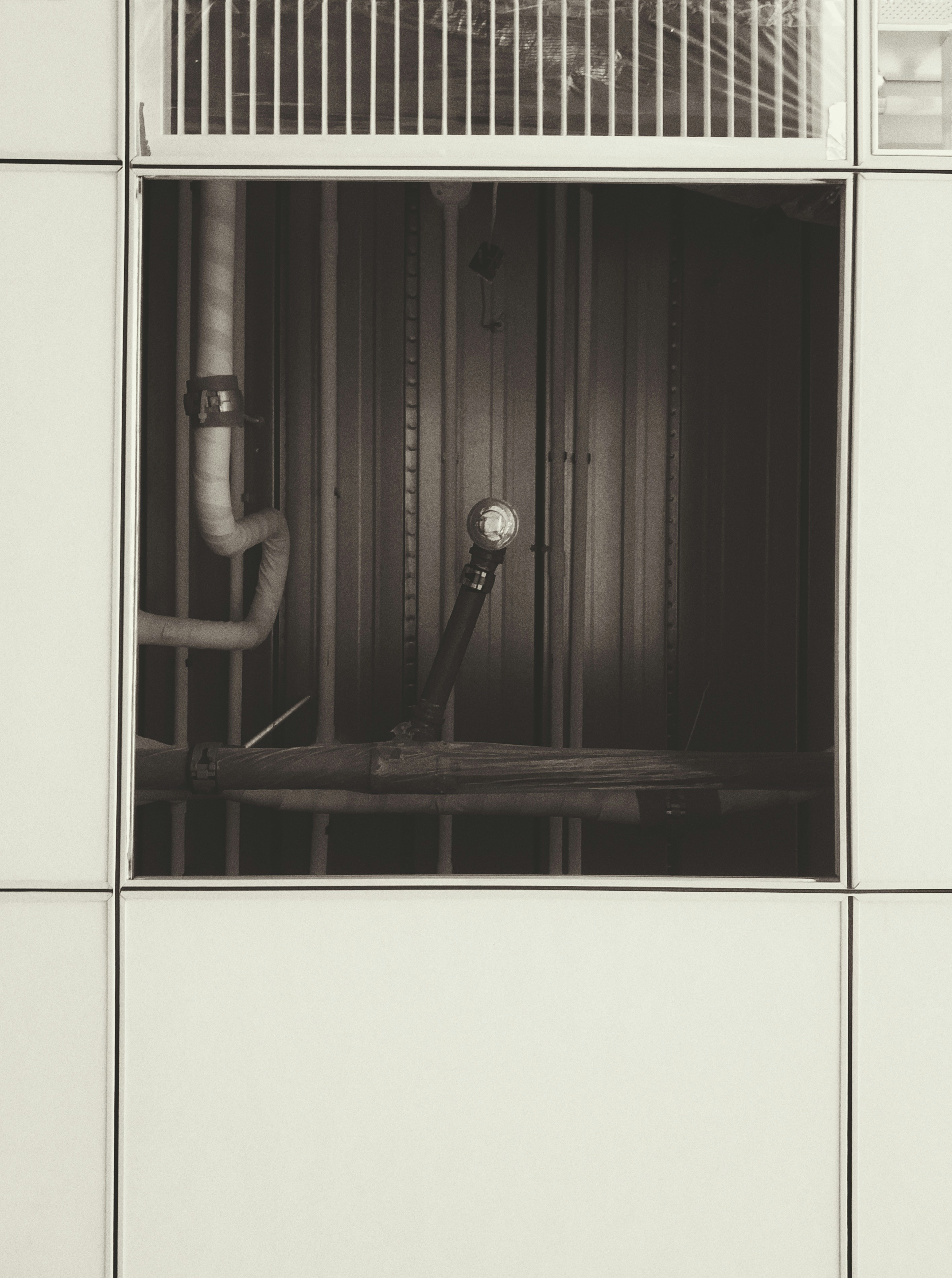 a black and white photo of pipes in a building