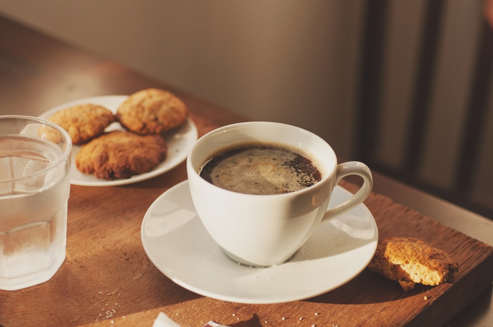 tazza di caffè e tre biscotti su piattino