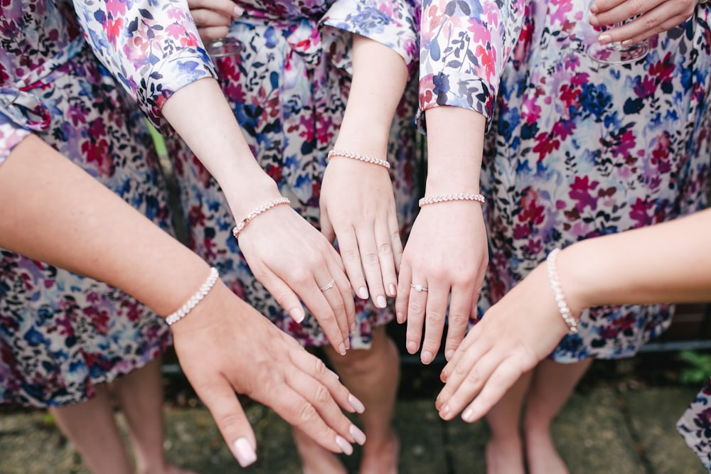 four women putting their hands together at the center