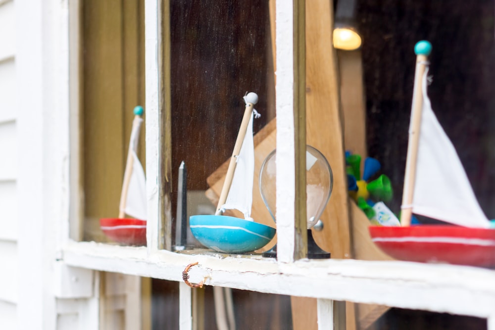 two red and one teal sailboat toys