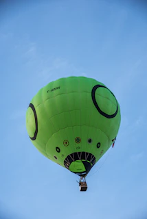 Passengers smiling excitedly as they prepare to take off in a hot air balloon branded with the 'Hơi Thăng' logo.