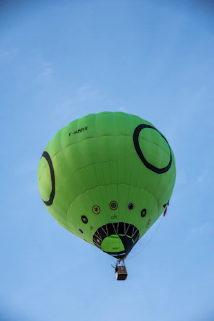 Passengers smiling excitedly as they prepare to take off in a hot air balloon branded with the 'Hơi Thăng' logo.