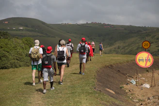 A group of walkers on a gently sloping path in Dolina Chochołowska, some using the hypershell for extra support.