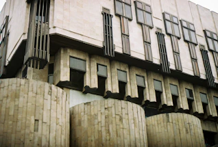 A modern brutalist office building exterior with strong geometric lines and concrete textures.