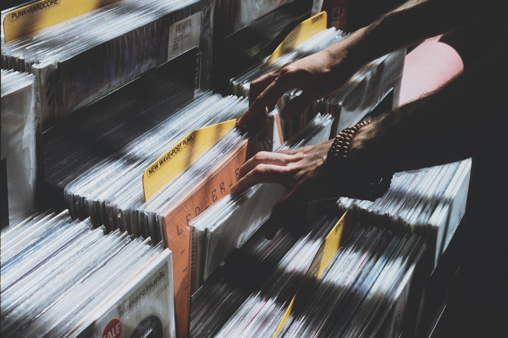 person taking photo of assorted vinyl album