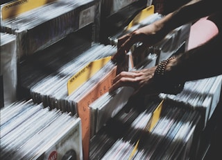 person taking photo of assorted vinyl album