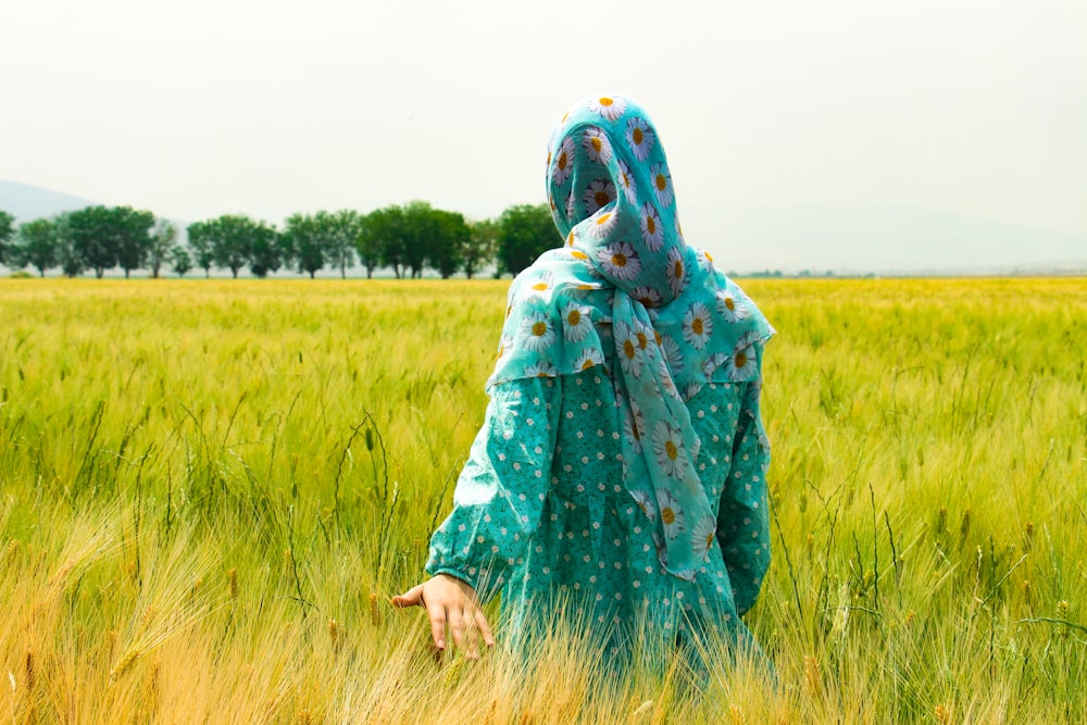 femme marchant sur le champ d’herbe verte